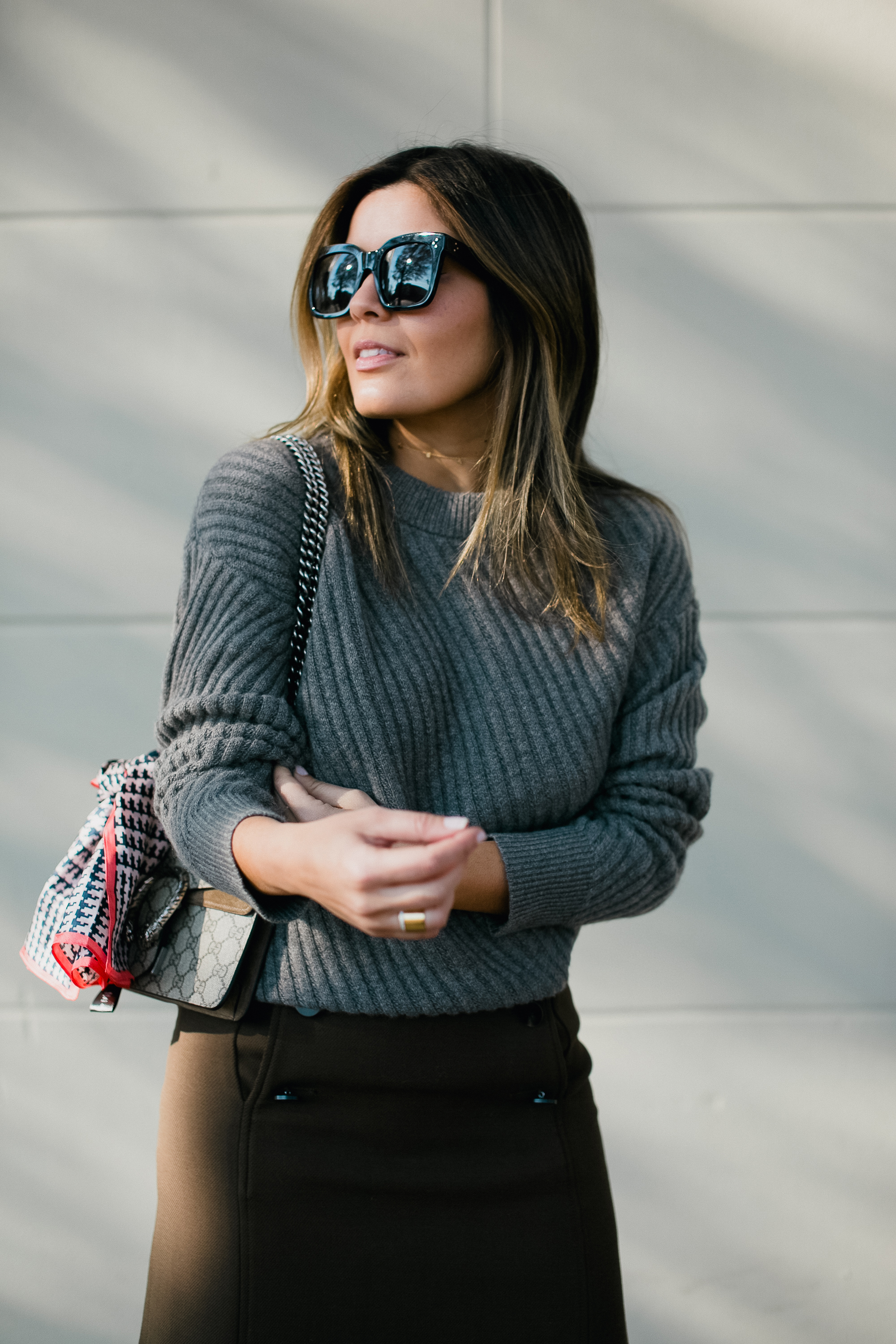 Blogger Sara Azani of Style MBA wears an Ann Taylor Stitched Cashmere Sweater, Ann Taylor Button Fron A-Line Skirt, Ann Taylor Anna Marie Heeled Suede Boots, and Ann Taylor boardwalk Sunglasses, and Ann Taylor houndstooth Silk Little Scarf from the Ann Taylor Silk Littles Collection.