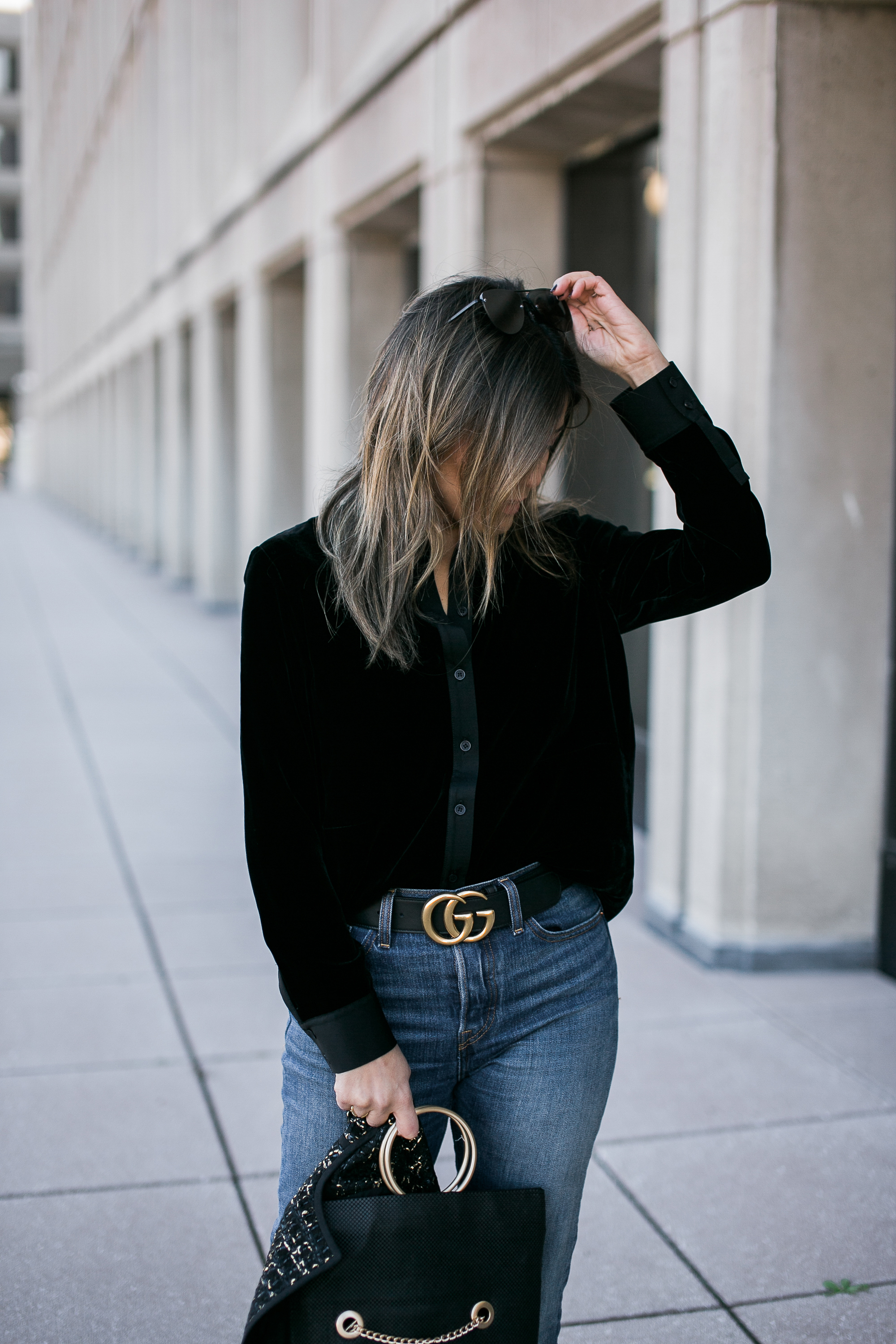 Blogger Sara Azani of Style MBA wearing a black Gucci leather belt with double G buckle, 5 Disc Choker Necklace, Whiting & Davis Fold-Over Tote, LEVI'S Wedgie Skinny Jean, Lafayette 148 New York tweed jacket, and Vince portia point toe pump as part of her black and gold look in front of a stone building in Washington, DC.