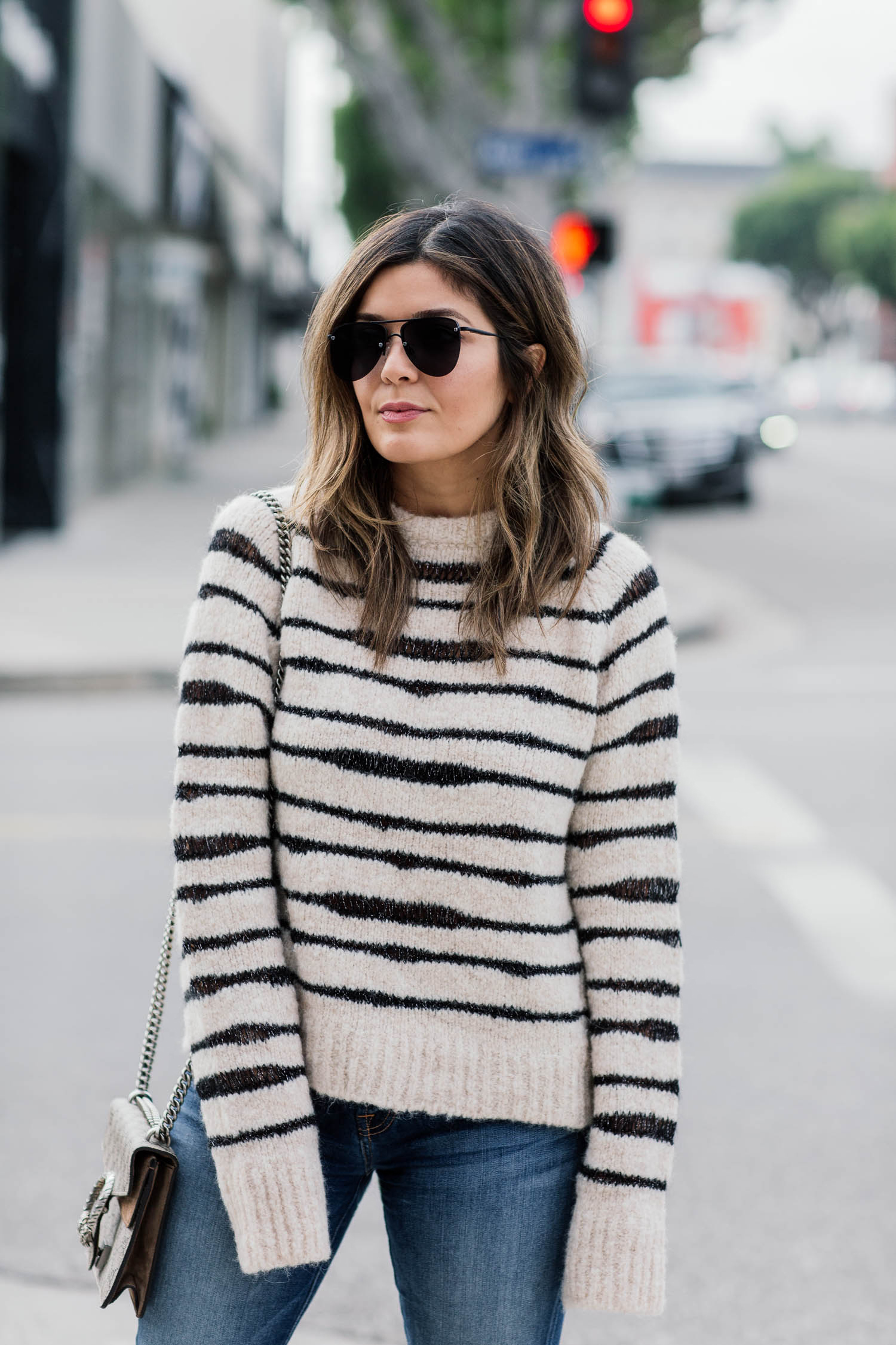 Blogger Sara Azani of Style MBA wearing Zadig and Voltaire white and black knit sweater, 7 For All Mankind crop skinny jeans, Steve Madden Stecy nude high-heeled sandal, Le Specs sunglasses, and a Gucci bag.