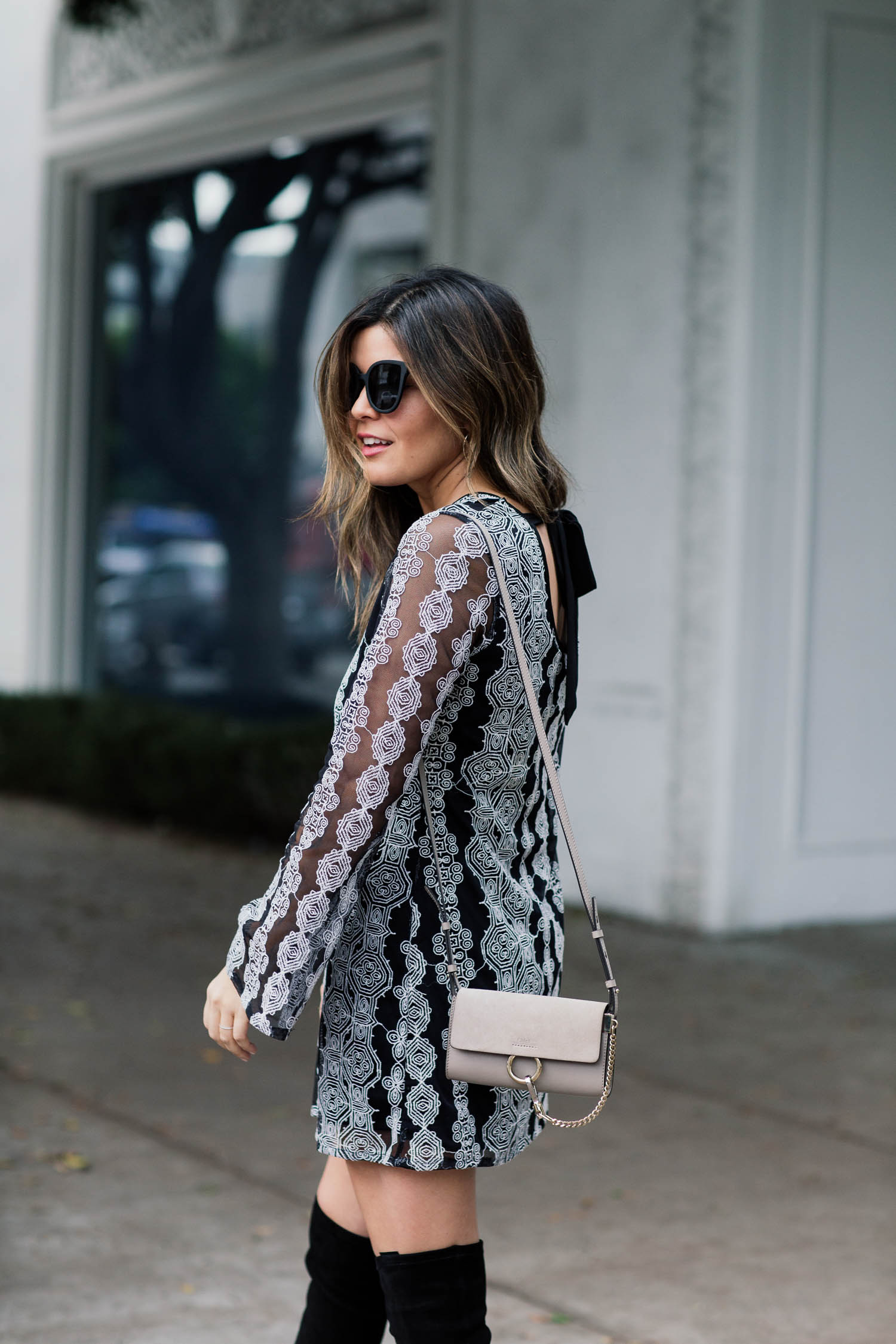 Blogger Sara Azani of Style MBA, a petite brunette woman, wears Band of Gypsies Geometric Print Dress via Nordstrom, Dolce Vita OTK Sparrow Thigh High Almond Toe Boot, Quay Australia Sunglasses, and a Chloé Mini Faye Suede & Leather Wallet on a Chain as part of a black and white outfit.